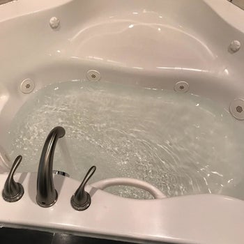 Reviewer photo of the tub looking cleaner and filled with clean water