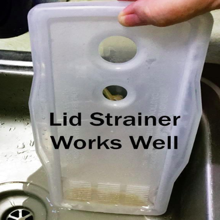A reviewer straining the pasta water using the lid of the pasta cooker