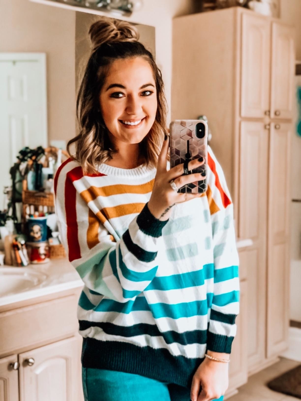 reviewer wears orange to blue gradient striped sweater