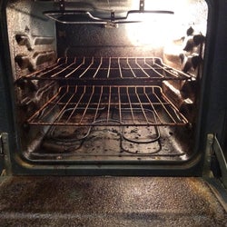 Another reviewer's dirty oven, which has a thick layer of black grime on it