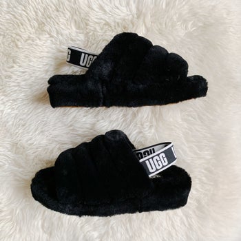 The fluffy slippers with a band around the back with the Ugg logo on it