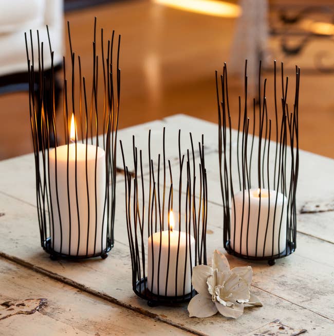 three candle holders with think black stripes surrounding the votive candle