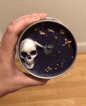 gif of a buzzfeed editor holding the necromancer candle and showing how it glitters