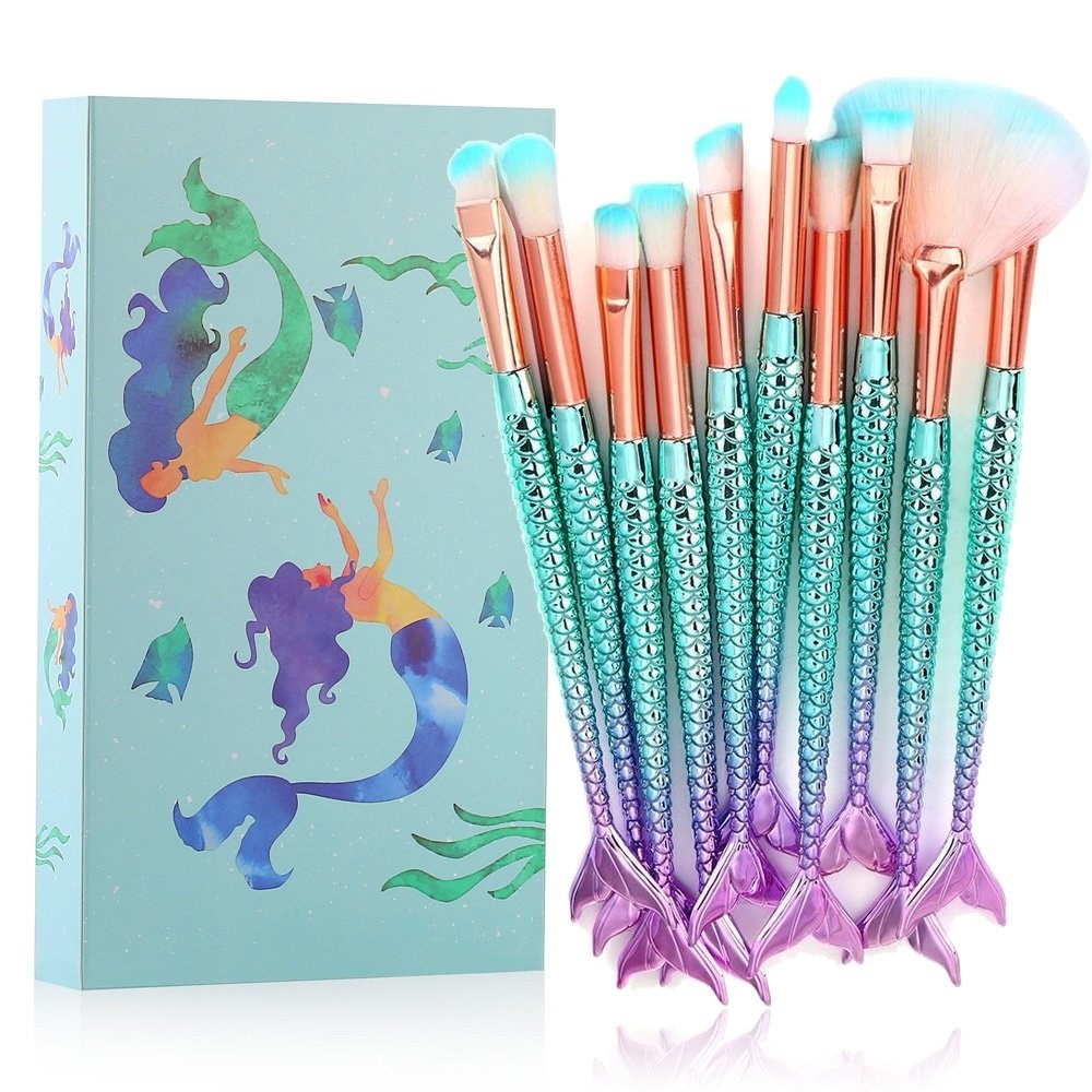 A set of fluffy makeup brushes with handles in the shape of mermaid fins