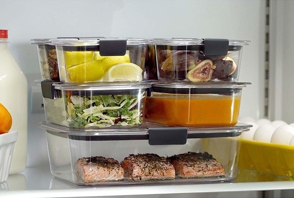 Glass containers stacked on each other holding different foods inside a fridge