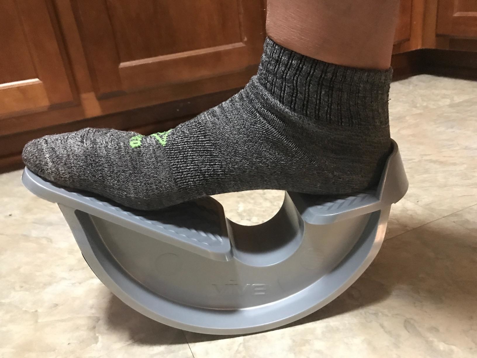 A reviewer&#x27;s foot resting on the semi-circle shaped rocker