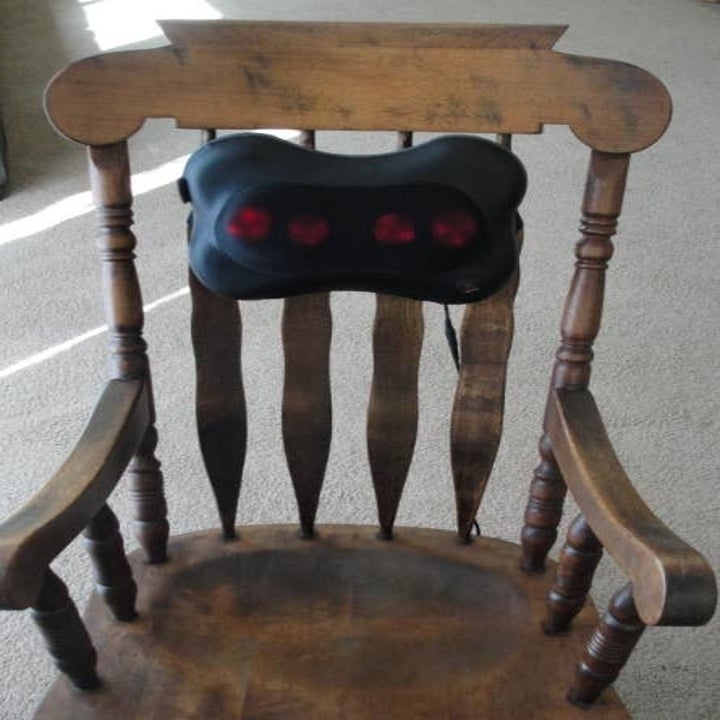 Reviewer image of the massage pillow attached to a wooden chair