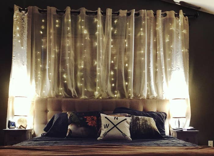 Reviewer&#x27;s string lights above their quilted headboard