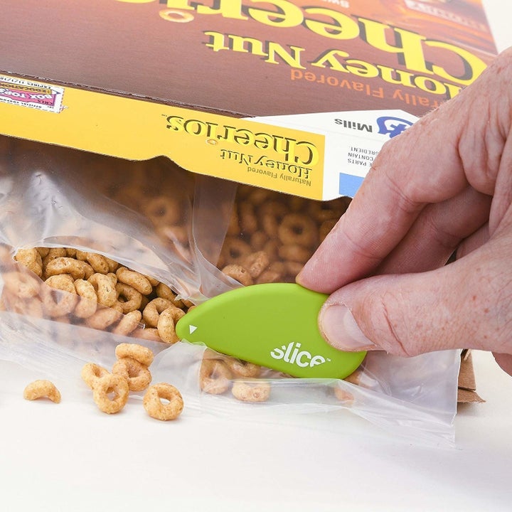 person using cutter to slice open a bag of cereal