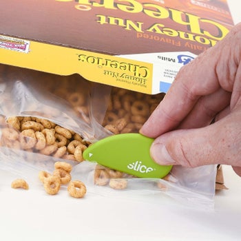 Another hand using it to open a bag of cereal