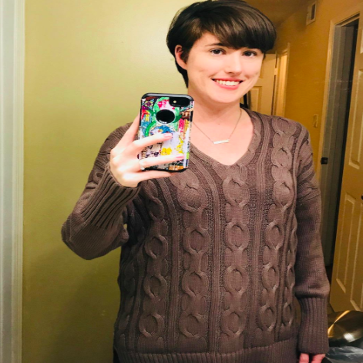A reviewer wearing the sweater in brown
