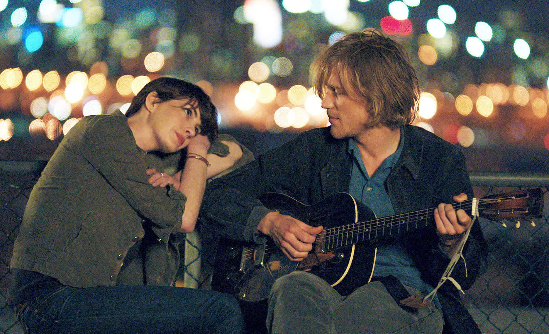 Anne Hathaway listens to Johnny Flynn play guitar