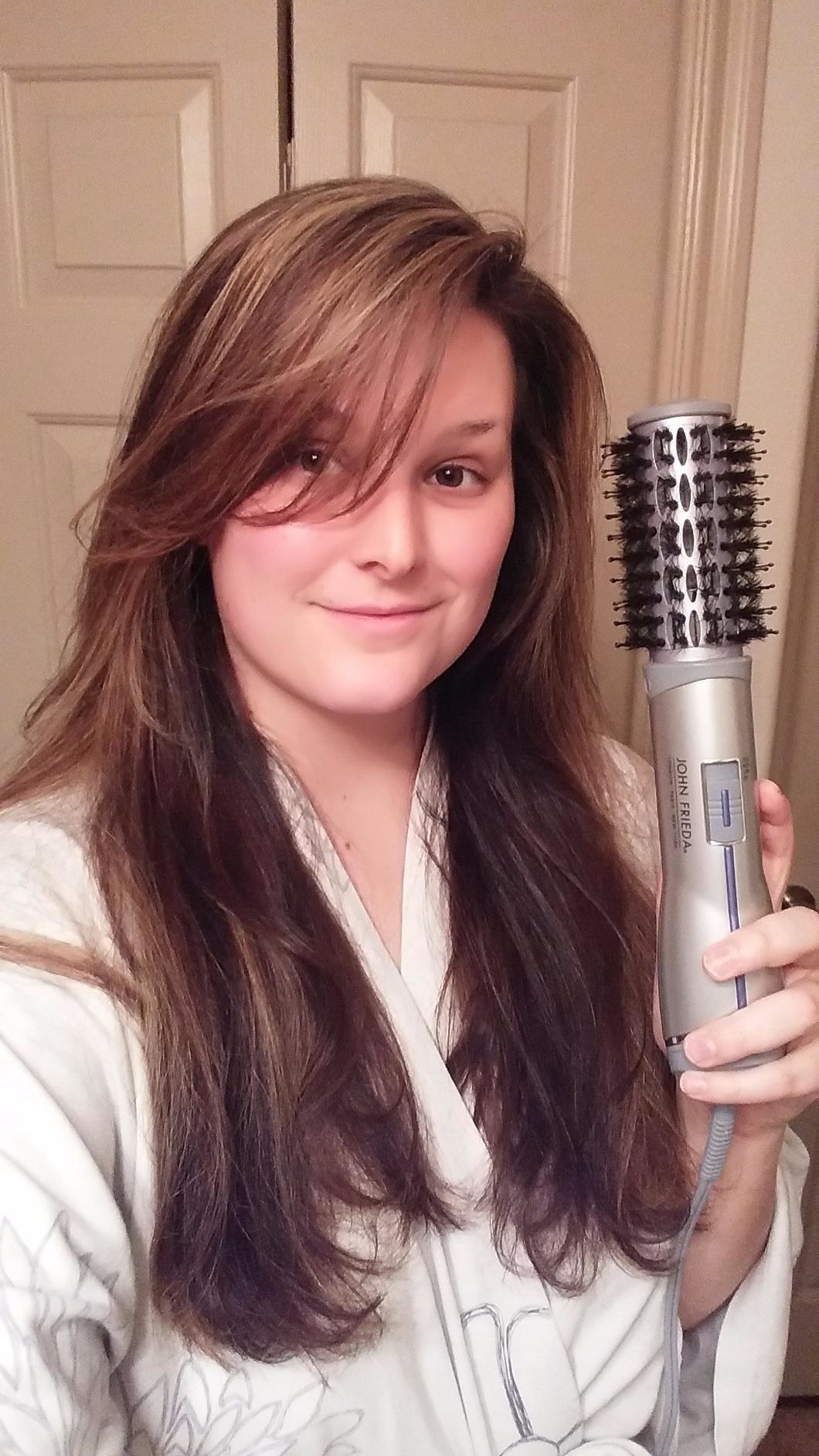 reviewer with blown out hair poses with bristled hot brush 