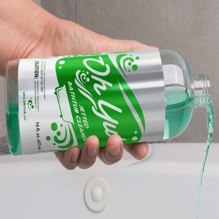 a model pouring the green liquid out of the oh yuk bottle