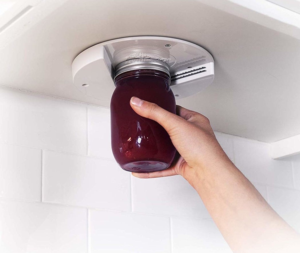 hand opens jar with wedge attached under cabinet 