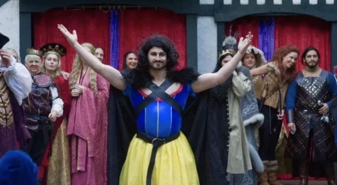 A man in a Snow White dress with a cape and Jon Snow from Game of Thrones hair
