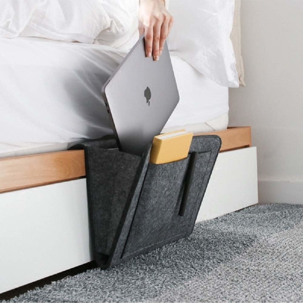 A person sliding a laptop into the bedside caddy