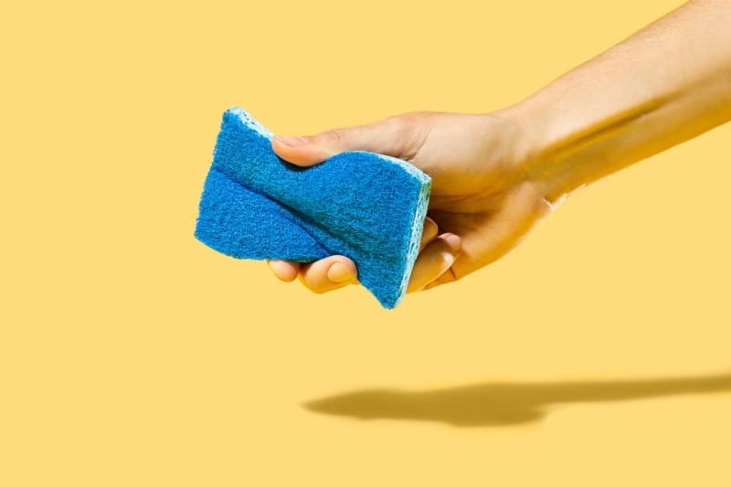 hand holding the blue sponge 