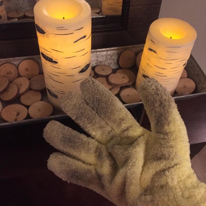 the glove full of dust after cleaning around candles on a surface 