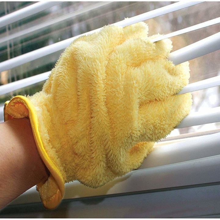 dusting glove being used to clean blinds 