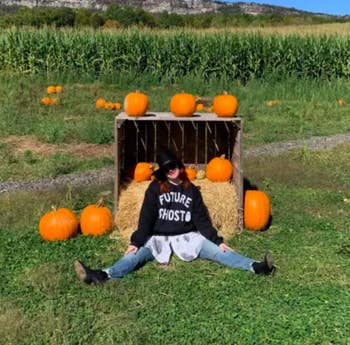 myself wearing the sweatshirt in a pumpkin patch