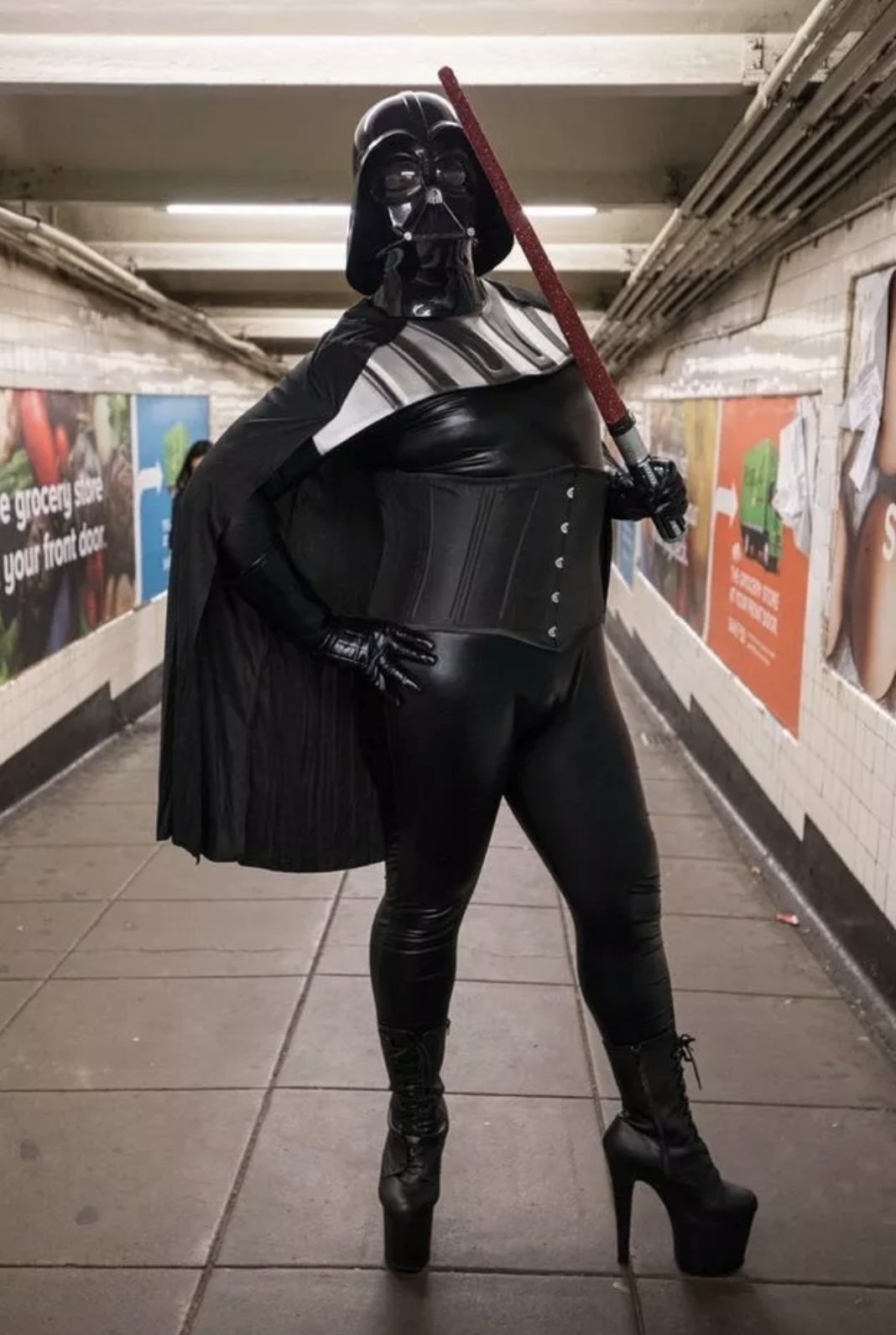 Someone dressed as darth vader in a corset, cape, and high heels