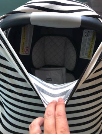 a reviewer showing how stretchy the car seat cover is