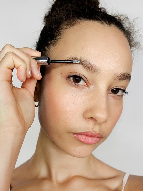 model uses the brow brush