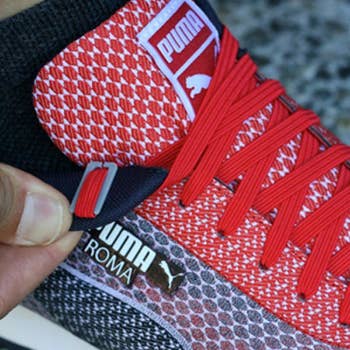 person showing the end tab of the laces added to shoes