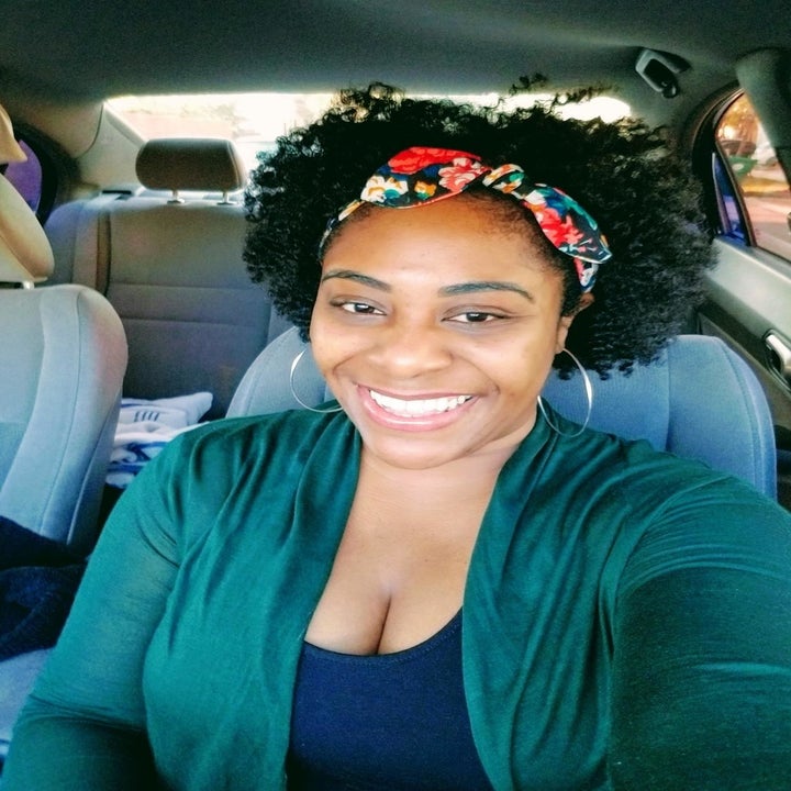A woman with a curly afro with a floral print headband.
