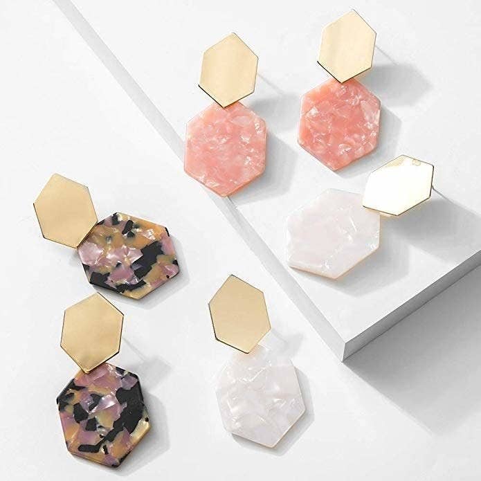 Three pairs of the earrings in a geometric design with a top gold piece and a resin bottom piece in different colors