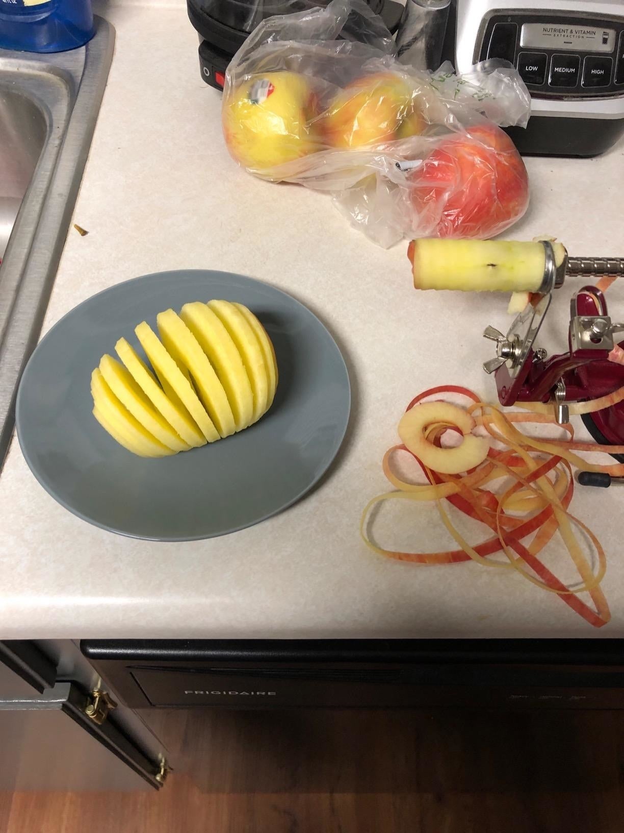 The peeled apple, sliced evenly successful  the device