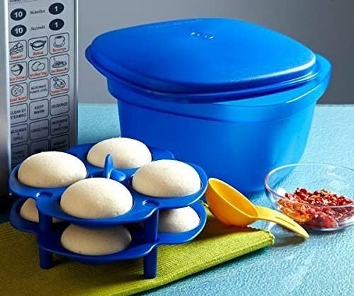 The multipurpose cooking tool pictured with a measuring spoon and cooked idlis in its idli maker.