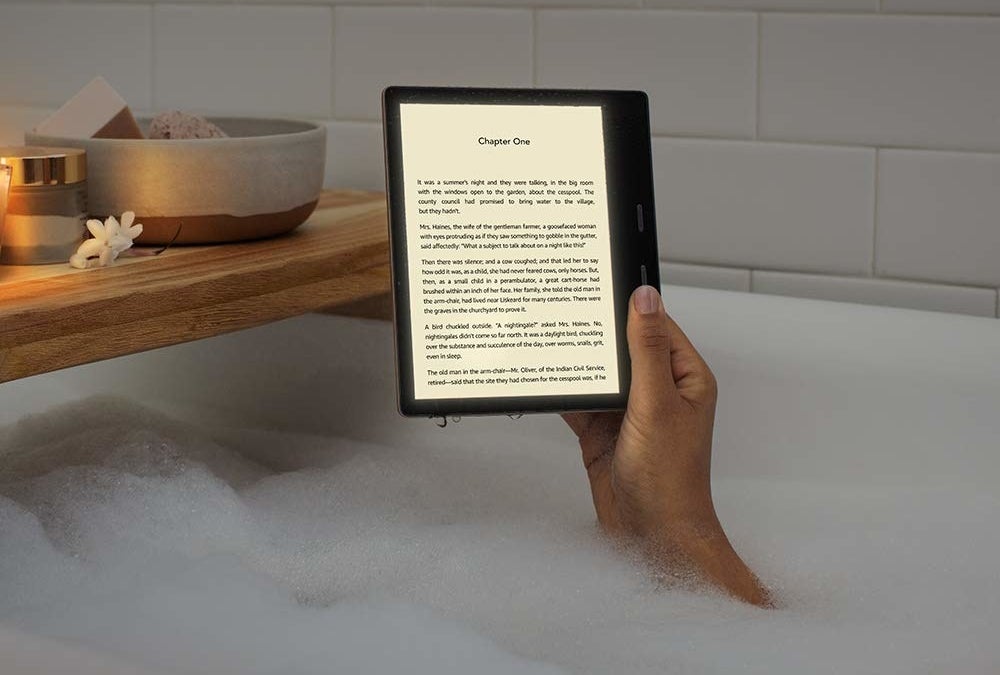 Hand holding Kindle Oasis in bathtub 