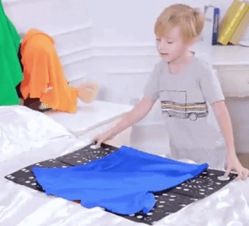 a GIF of a kid using the folding board to fold a t-shirt. By closing the two sides of the board, it easily folds it in the same style as most retail stores fold t-shirts