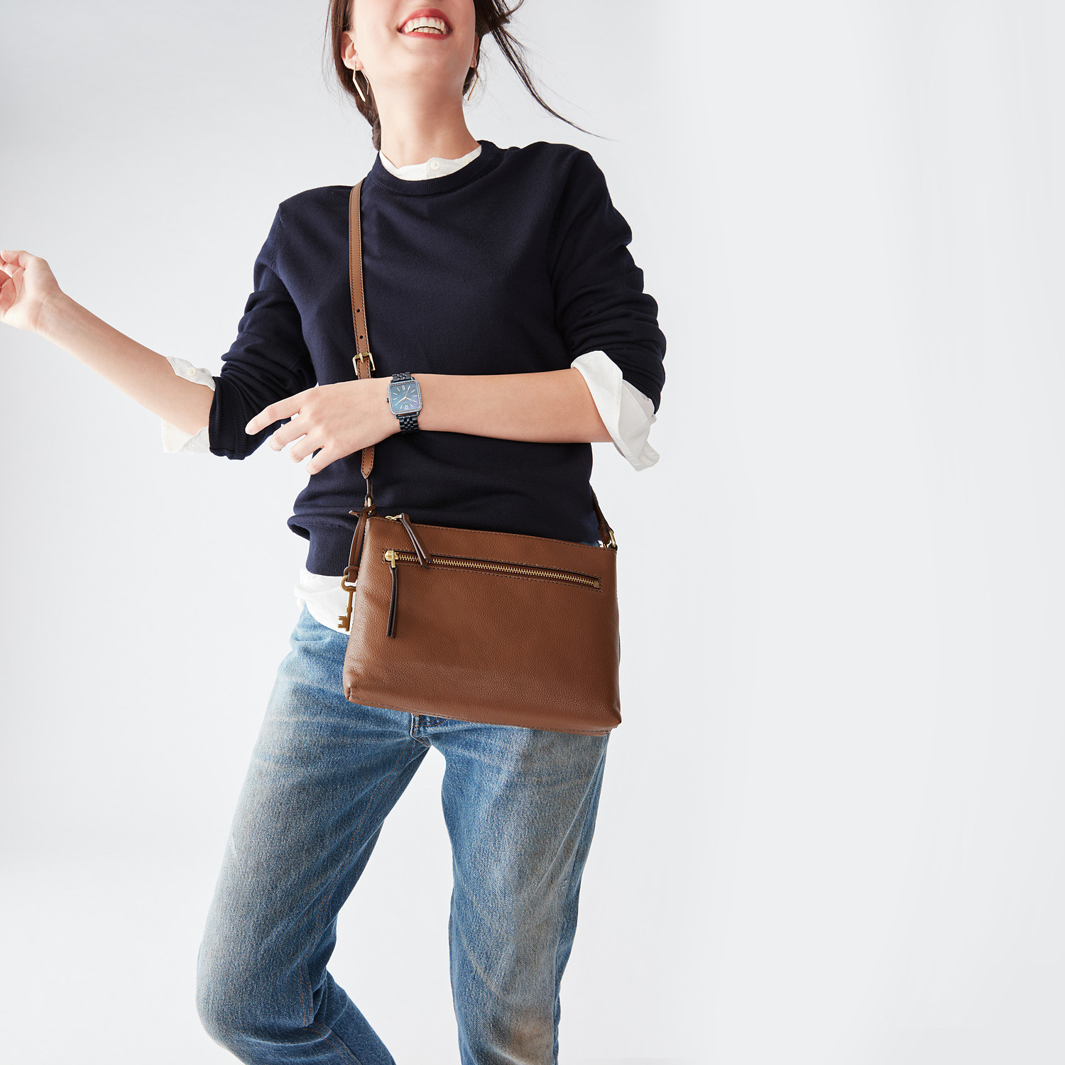 Model with the crossbody rectangle-shaped small bag across their shoulder with a zipper across the top and upper front