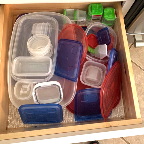Reviewer image of unorganized drawer with containers and lids