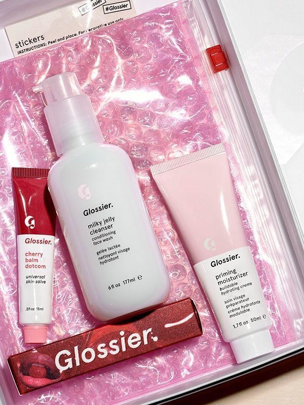 The three products included in the kit on top of the signature pink bag