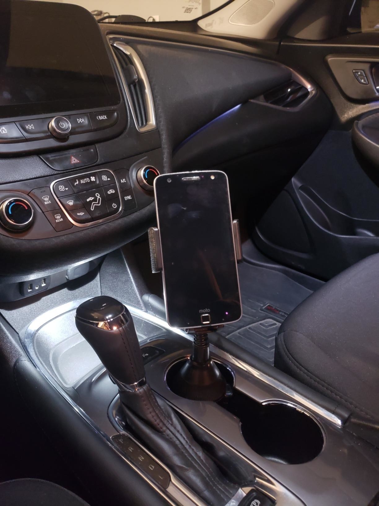 The phone mount in a reviewer's car cupholder