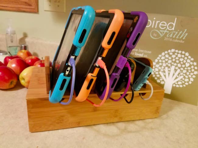wooden holder with slots fo holding phones and tablets while they charge