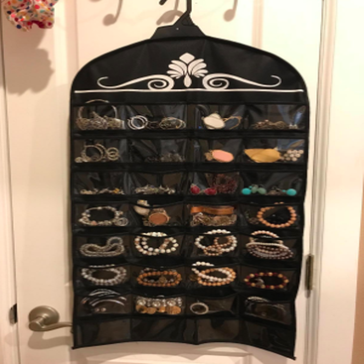 jewelry organizer hanging from coat hanger with clear pockets for jewelry storage