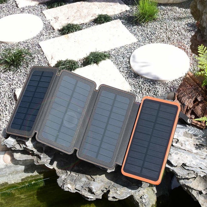 Power bank kept on the floor with solar panels exposed to charge under the sun.