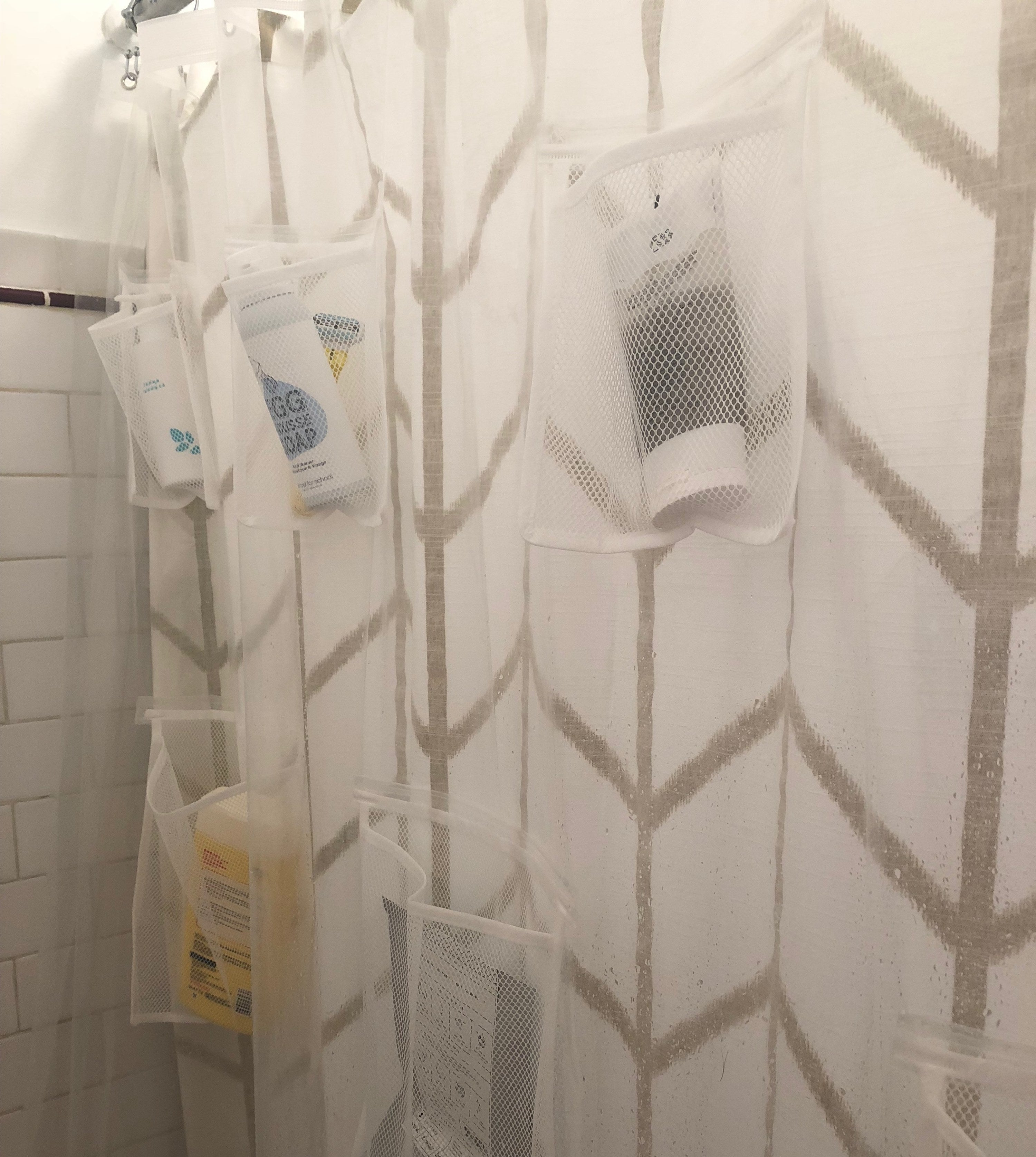 A shower with the pocketed shower curtain liner hanging up