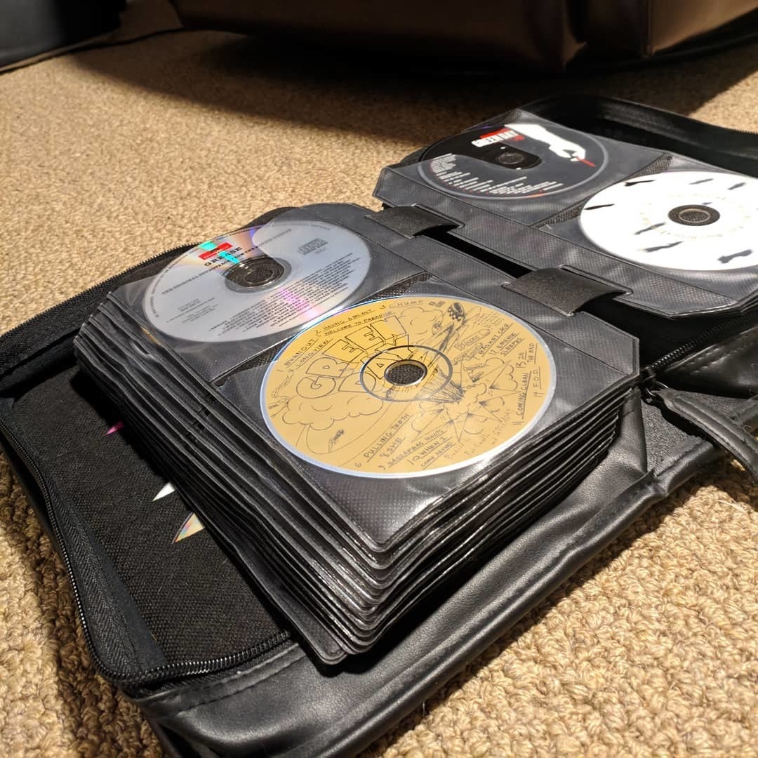A zip-up CD case with a collection of Green Day CDs