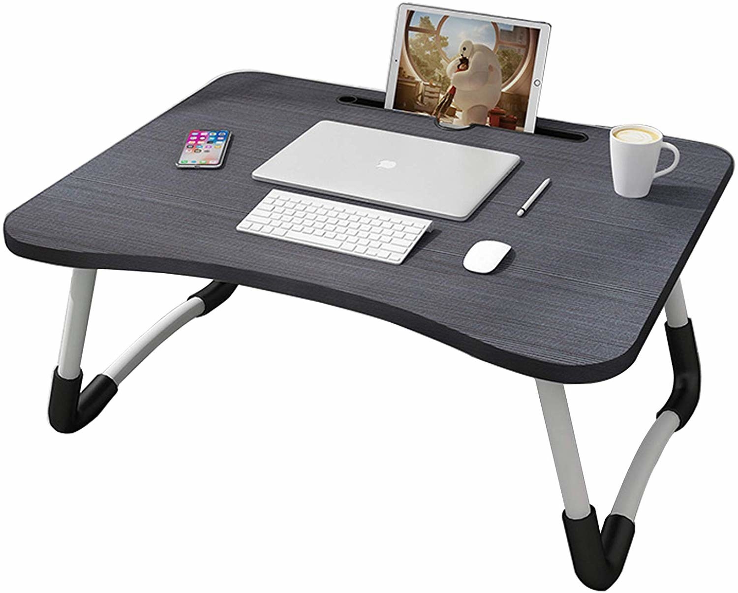 A foldable laptop table with multiple devices and a cup of coffee on it