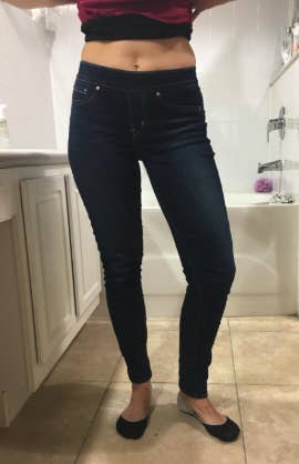 a reviewer wearing the jeans in a dark blue 