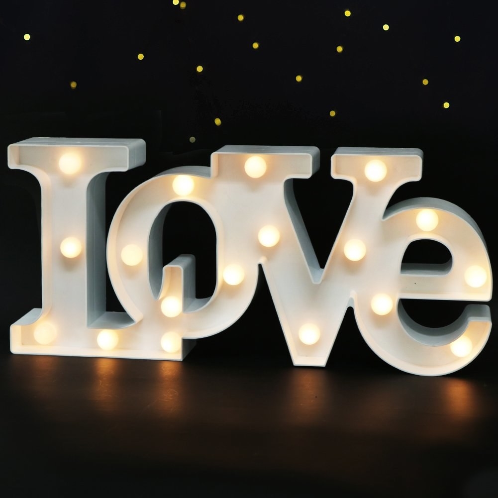 White metal light with exposed bulbs spelling out LOVE