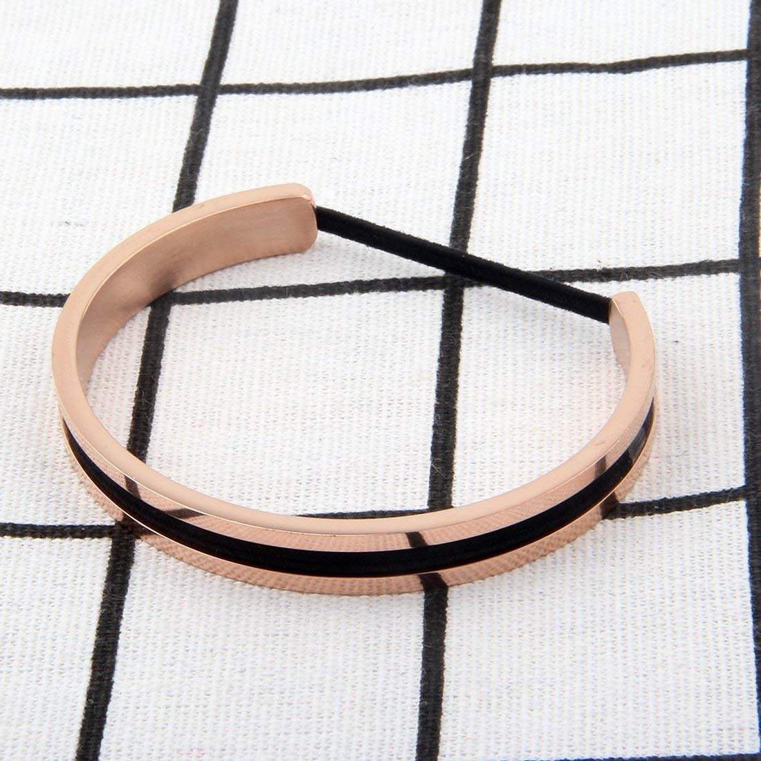 A gold bracelet with a groove for keeping a hair tie