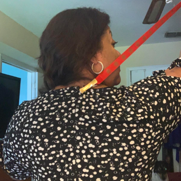 reviewer using the clamp on a red ribbon to zip a dress