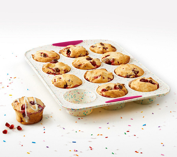 White muffin pan with pink handles and multi-colored sprinkles decorated